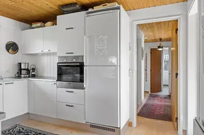a kitchen with white cabinets and a refrigerator at BL1677-Saltum-Sikahjortvej-6 in Saltum