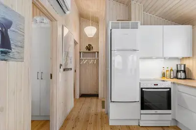 a white refrigerator in a kitchen with wooden walls at BL1620-Saltum-Foraarsvangen-7 in Saltum