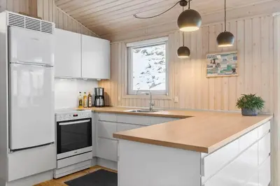a kitchen with white cabinets and a white refrigerator at BL1620-Saltum-Foraarsvangen-7 in Saltum