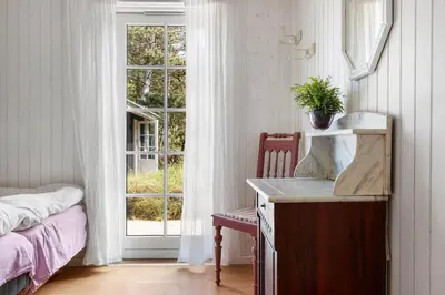 a bedroom with a desk and a window with a plant at BL1082-Blokhus-Klintevej-12 in Blokhus