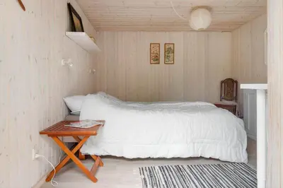 a bedroom with a white bed and a table at BL1082-Blokhus-Klintevej-12 in Blokhus