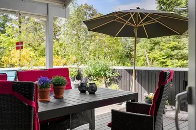 a wooden table with an umbrella on a patio at BL1666-Saltum-Vikingebanke-5 in Saltum