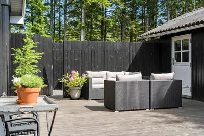 a patio with four wicker chairs and a fence at BL1666-Saltum-Vikingebanke-5 in Saltum