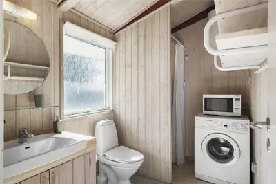 a bathroom with a toilet and a sink and a washing machine at BL1419-Saltum-Skanderborgvej-13 in Saltum
