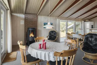 a room with a table and chairs and a fireplace at BL1419-Saltum-Skanderborgvej-13 in Saltum