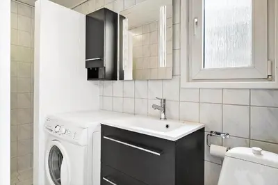 a small bathroom with a sink and a washing machine at BL253-Blokhus-Jaegerbakken-9 in Blokhus