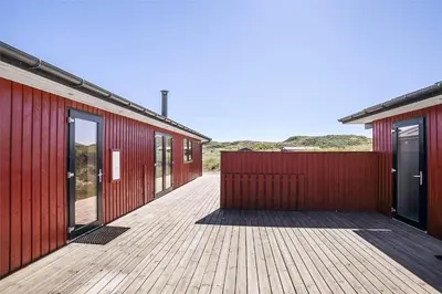 a wooden walkway between two buildings with red walls at BL117-Pandrup-Marsvinet-30 in Pandrup