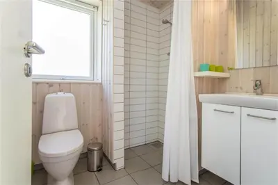 a bathroom with a toilet and a sink and a window at BL117-Pandrup-Marsvinet-30 in Pandrup