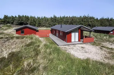 a small red and black house on a beach at BL117-Pandrup-Marsvinet-30 in Pandrup