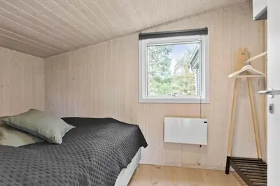 a bedroom with a bed and a window at BL1335-Blokhus-Havorns-Alle-32 in Blokhus
