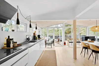 a kitchen with white cabinets and a dining room at BL1335-Blokhus-Havorns-Alle-32 in Blokhus