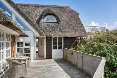 a thatch roof house with a wooden walkway at BL1647-Saltum-Graabakken-46 in Saltum