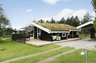 a large black house with a grass roof at BL485-Blokhus-Sandtoften-29 in Blokhus