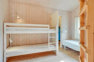 a room with two bunk beds and a bed at BL813-Blokhus-Klitvejen-12 in Blokhus