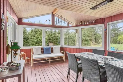 a screened in porch with a table and chairs at BL1332-Pandrup-Rodhusparken-78 in Pandrup