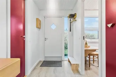 a room with a red door and a table with a desk at BL1767-Saltum-Saltum-Strandvej-209 in Saltum