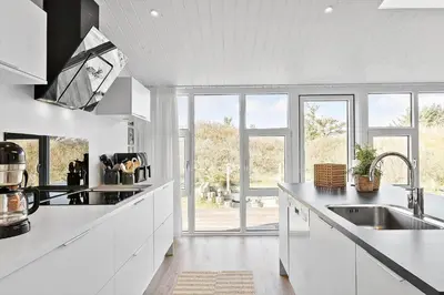 a kitchen with white cabinets and a large window at BL1767-Saltum-Saltum-Strandvej-209 in Saltum