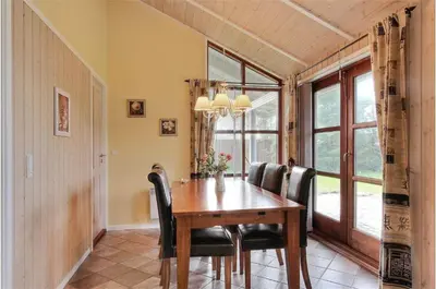 a dining room with a wooden table and black chairs at BL861-Blokhus-Pirupshvarrevej-49 in Blokhus