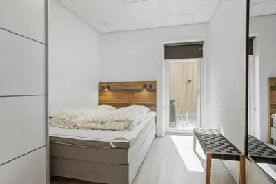 a bedroom with a large bed and a window at BL1405-Blokhus-Sletten-12 in Blokhus