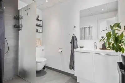 a white bathroom with a toilet and a sink at BL1573-Blokhus-Soren-Tjenersvej-3 in Blokhus