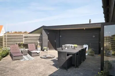 a patio with a table and chairs on a patio at BL1573-Blokhus-Soren-Tjenersvej-3 in Blokhus