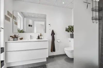 a white bathroom with a sink and a toilet at BL1573-Blokhus-Soren-Tjenersvej-3 in Blokhus