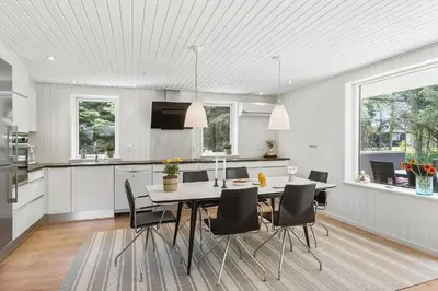 a kitchen and dining room with a table and chairs at BL1205-Blokhus-Quintusvej-26 in Blokhus