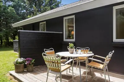 a patio with a table and chairs on a deck at BL1205-Blokhus-Quintusvej-26 in Blokhus