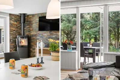 a kitchen and a living room with a table and a fireplace at BL1205-Blokhus-Quintusvej-26 in Blokhus