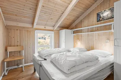 a large bed in a room with wooden walls at BL331-Saltum-Ornebjergvej-21 in Saltum