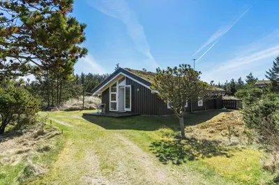 a small house on a hill with a yard at BL331-Saltum-Ornebjergvej-21 in Saltum