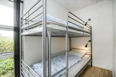 a bunk bed room with two bunk beds and a window at BL139-Blokhus-Klitvejen-4-A in Blokhus