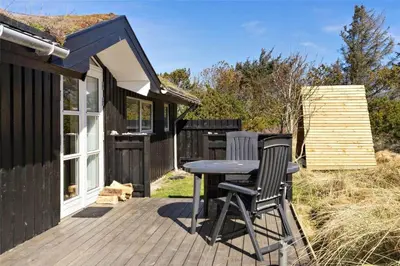 a wooden deck with two chairs and a table on a house at BL418-Pandrup-Hunetorp-Klitvej-141 in Pandrup