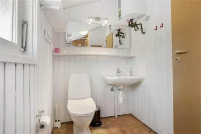 a white bathroom with a toilet and a sink at BL418-Pandrup-Hunetorp-Klitvej-141 in Pandrup