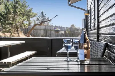 a bottle of wine and two glasses on a table at BL1601-Blokhus-Kristinesvej-15 in Blokhus