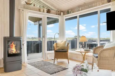 a living room with a fireplace in front of a window at BL203-Saltum-Karen-Mariesvej-67 in Saltum