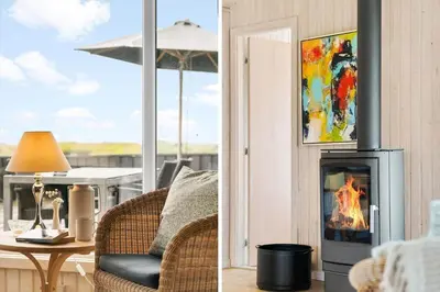 a fireplace in a living room with a chair and a table at BL203-Saltum-Karen-Mariesvej-67 in Saltum