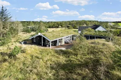 a house with a grass roof on top of a hill at BL1678-Pandrup-Hunetorp-Klitvej-1-B in Pandrup
