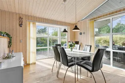 a dining room with a white table and black chairs at BL1678-Pandrup-Hunetorp-Klitvej-1-B in Pandrup