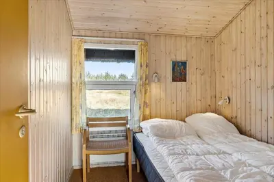 a small bedroom with a bed and a window at BL1749-Pandrup-Tunen-5 in Pandrup