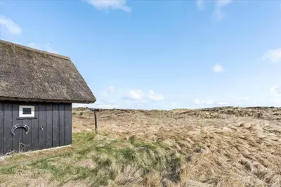 an old black building in a field of grass at BL1749-Pandrup-Tunen-5 in Pandrup