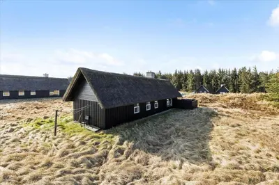 a small black building in a field of grass at BL1749-Pandrup-Tunen-5 in Pandrup