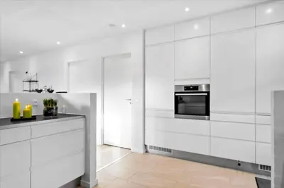 a white kitchen with white cabinets and a stove at BL1520-Blokhus-Klitgaardsvej-3-B in Blokhus