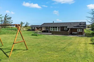 a wooden structure in front of a house at BL1715-Saltum-Kvansletten-15 in Saltum