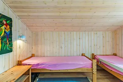 two beds in a room with wooden walls at BL1715-Saltum-Kvansletten-15 in Saltum