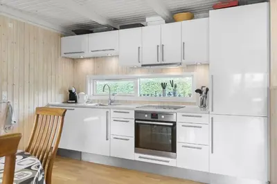 a kitchen with white cabinets and a window at BL1152-Blokhus-Septimusvej-28 in Blokhus