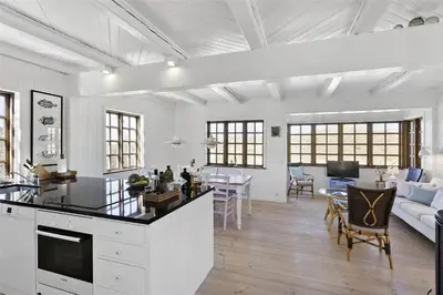 a white kitchen and living room with a table and chairs at BL982-Pandrup-Hunetorp-Klitvej-156 in Pandrup