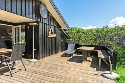 a wooden deck with a table and chairs on it at BL411-Pandrup-Hunetorp-Klitvej-223 in Pandrup