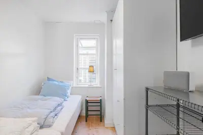 a white living room with a couch and a window at BL1527-Blokhus-Svinget-5 in Blokhus