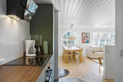 a kitchen with a counter top and a living room at BL1527-Blokhus-Svinget-5 in Blokhus